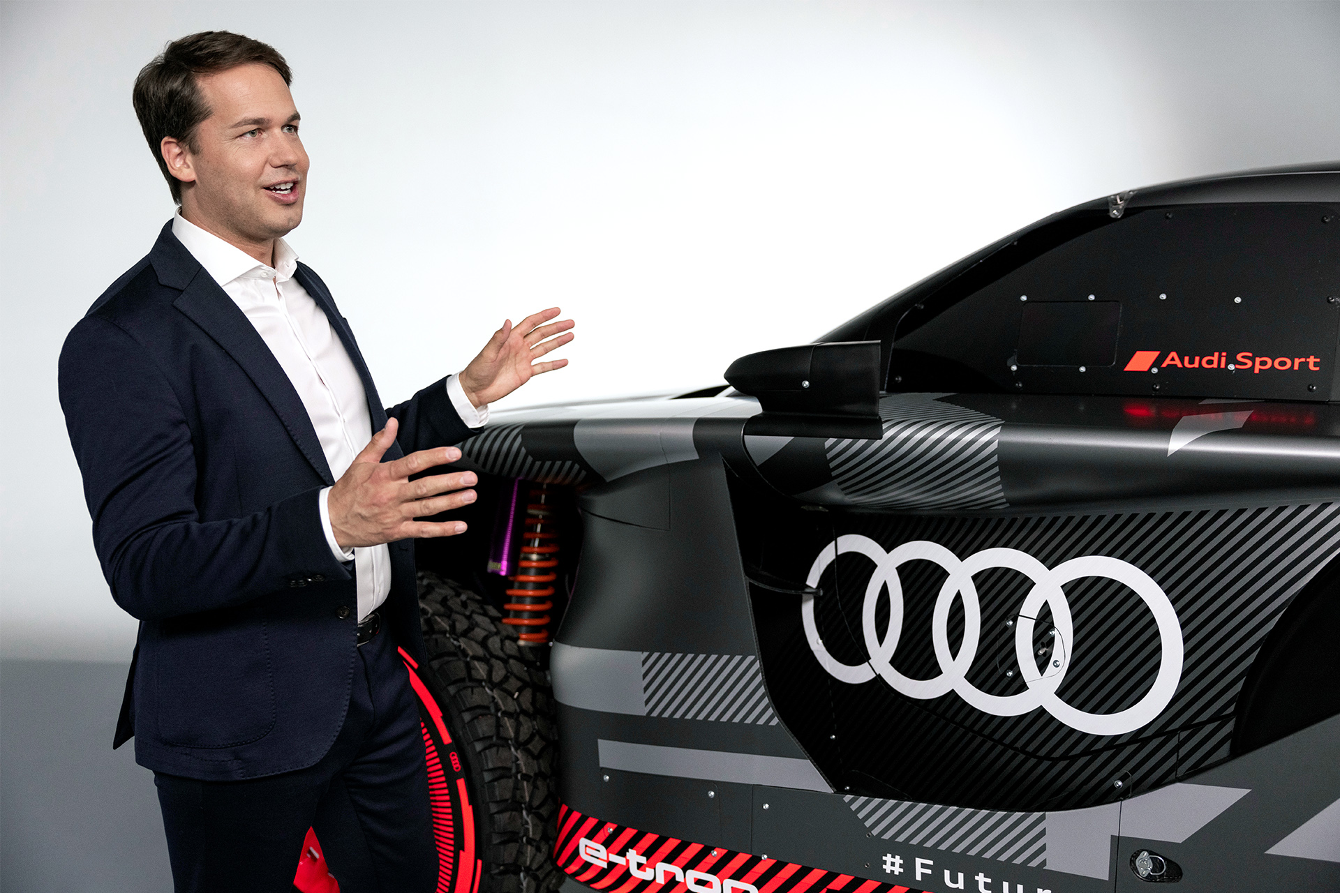  Julius Seebach stojący obok Audi RS Q e-tron i gestykulujący rękami.