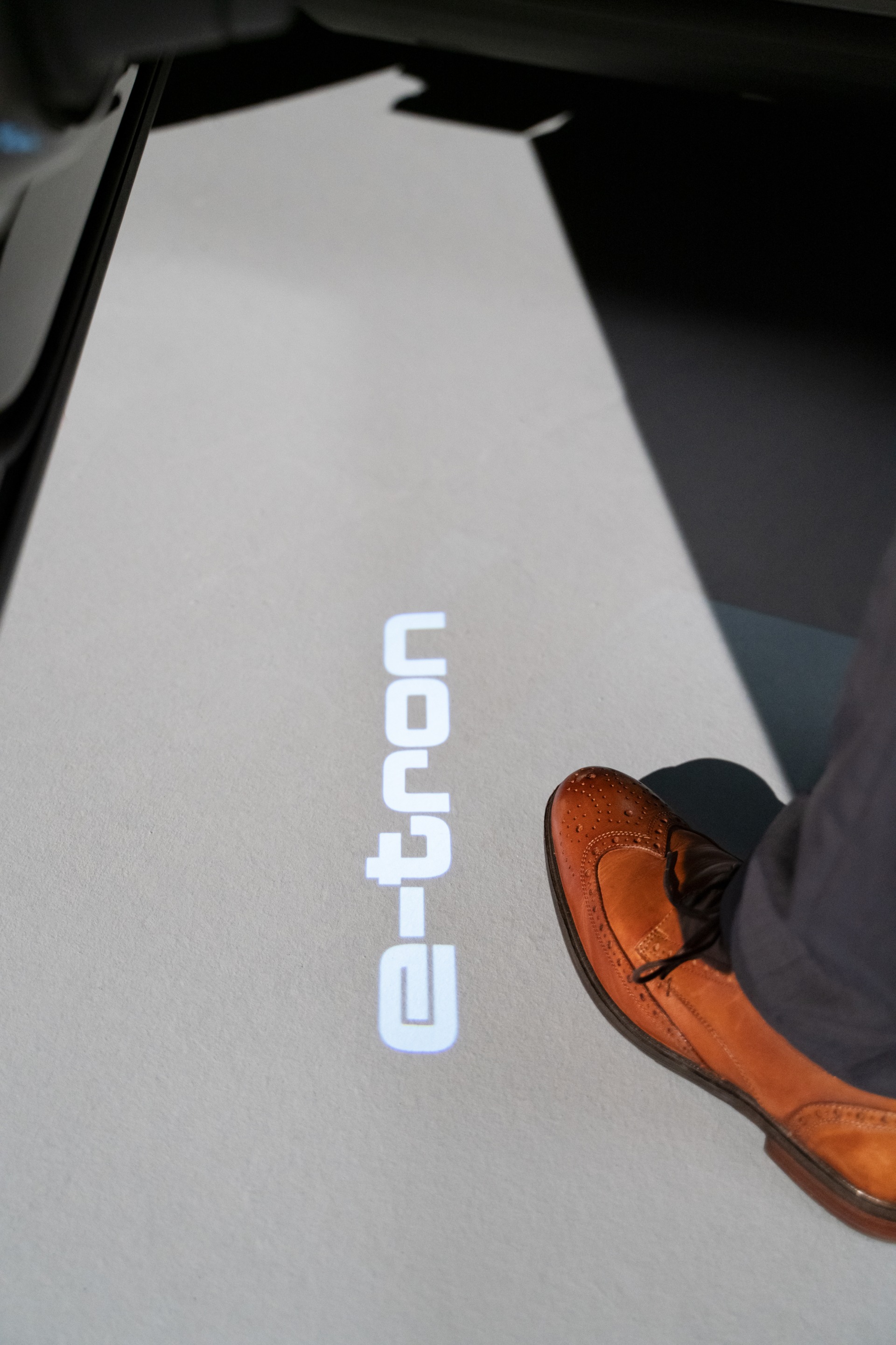 Logo e-tron jest wyświetlane na ziemi pod drzwiami kierowcy.