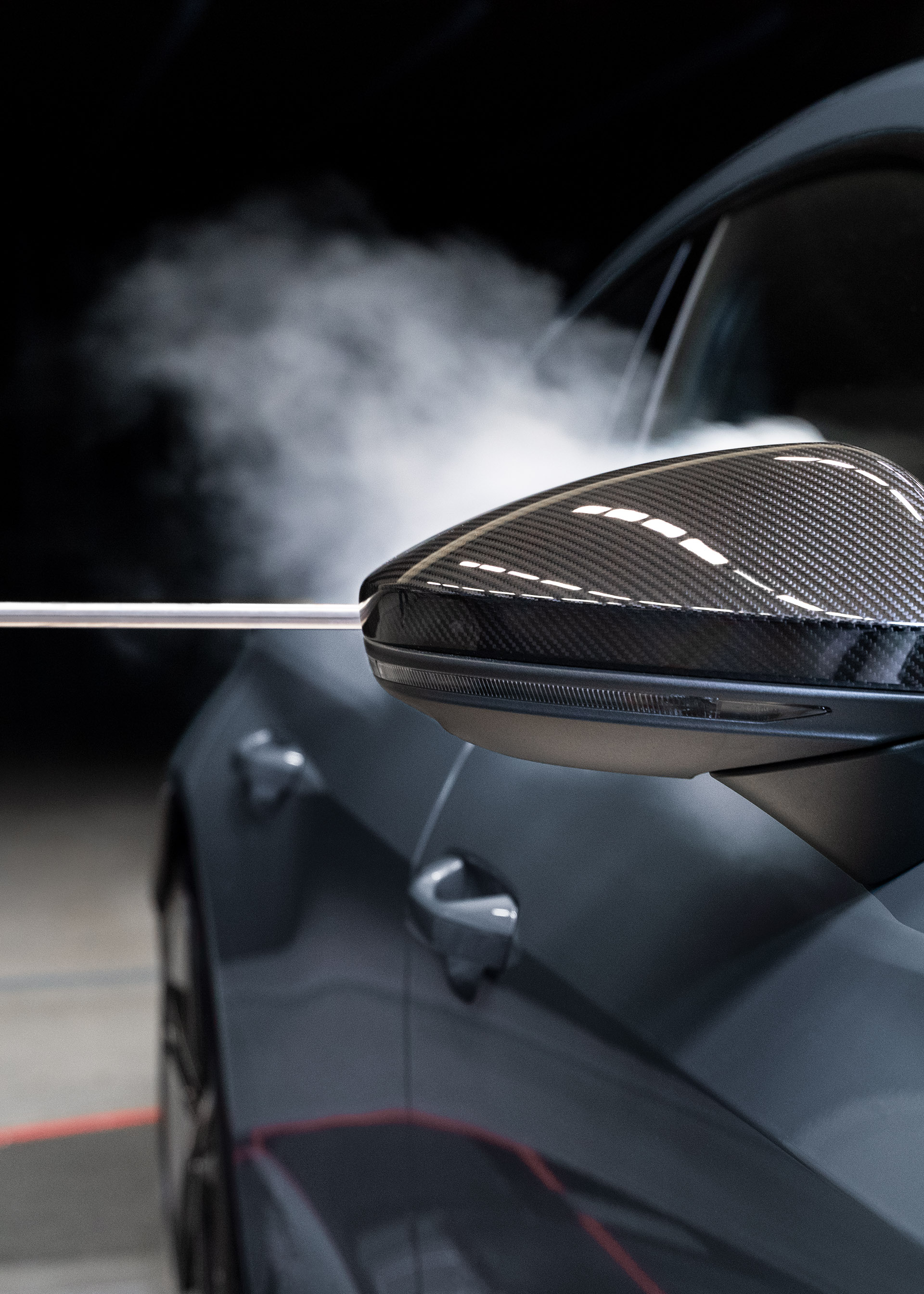 Dym unosi się nad karoserią Audi RS e-tron GT po minięciu lusterka zewnętrznego.