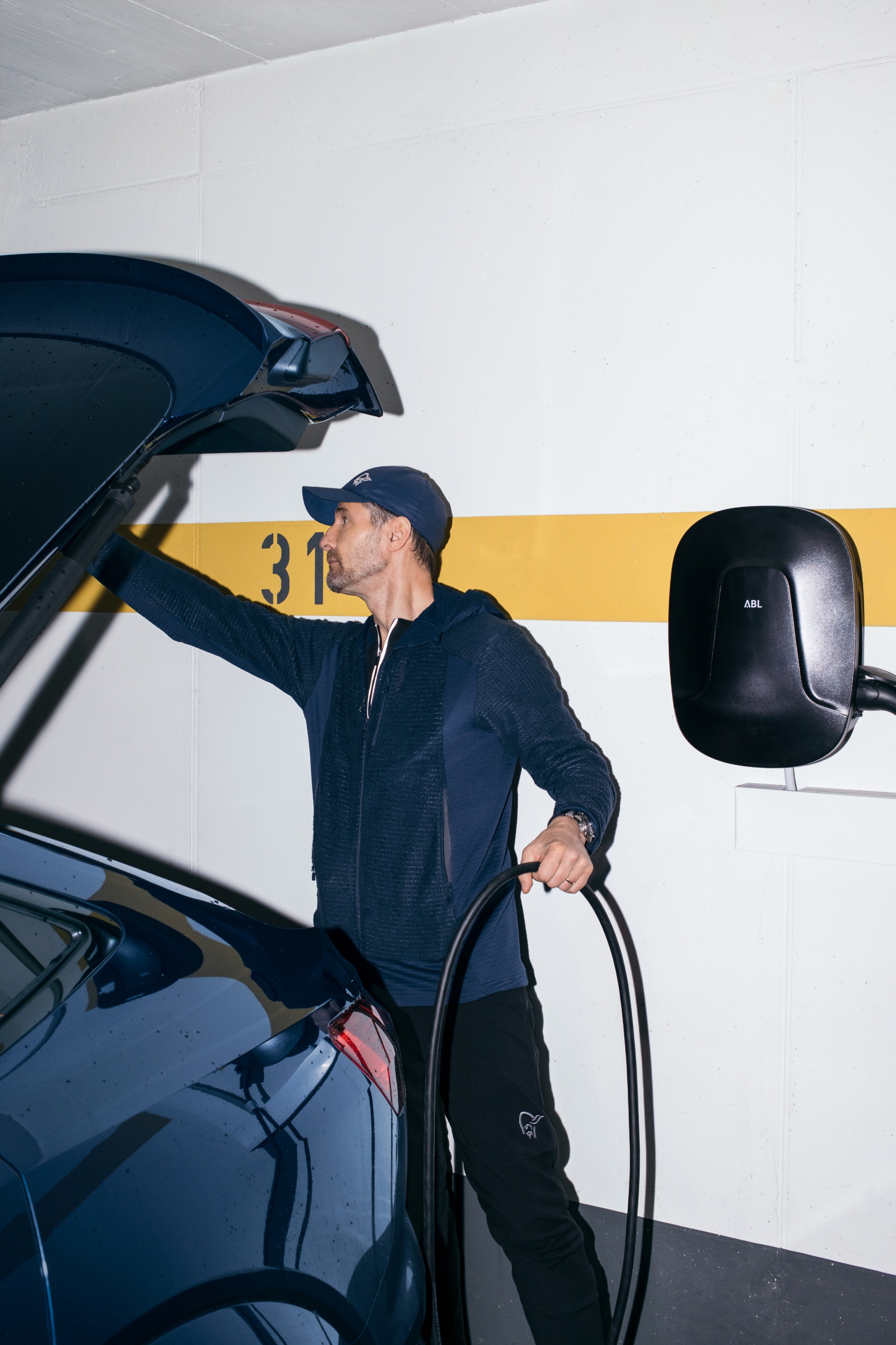 Copeland podłącza swoje Audi e-tron do puszki ściennej w swoim garażu.