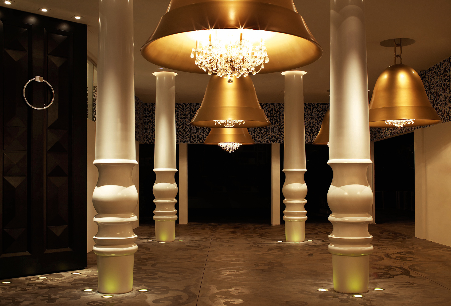  W holu pomiędzy białymi kolumnami wiszą ogromne, złote latarnie.