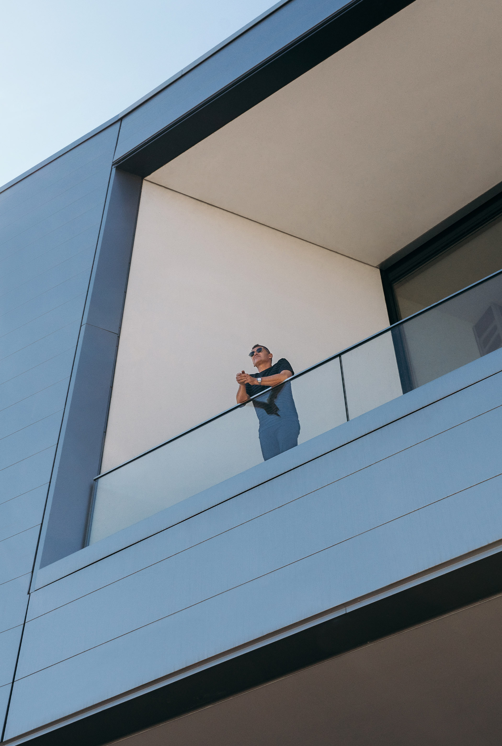 Tom Kristensen stoi na balkonie i spogląda na okolicę.