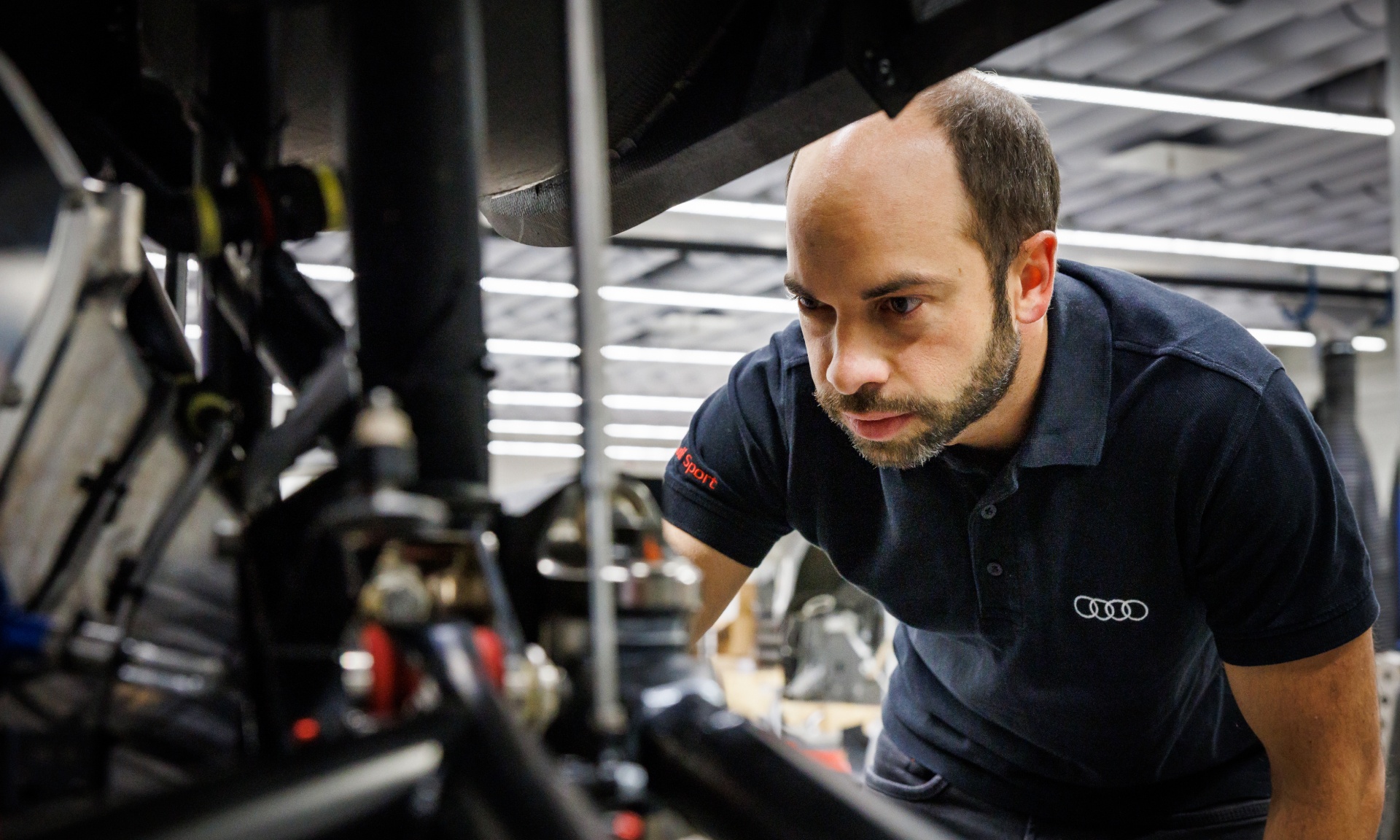 Benedikt Brunninger sprawdza szczegół zdemontowanego Audi RS Q e-tron.