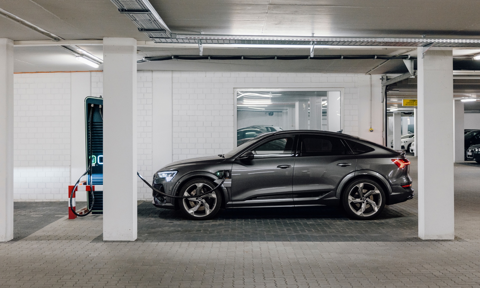 Audi e-tron S Sportback ładuje się na parkingu podziemnym.